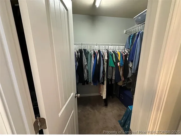a view of walk in closet with clothes