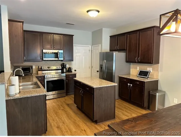 a kitchen with a refrigerator stove top oven and sink