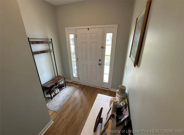 a view of room with wooden floor and mirror