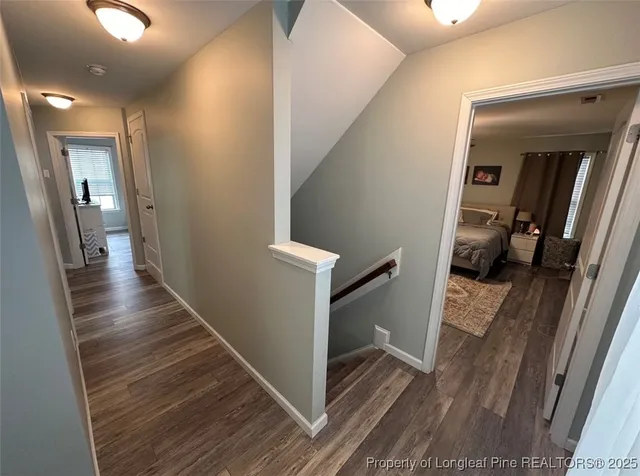 a view of a hallway with wooden floor and staircase