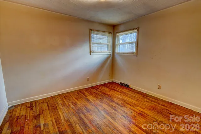 a view of a room with wooden floor and window
