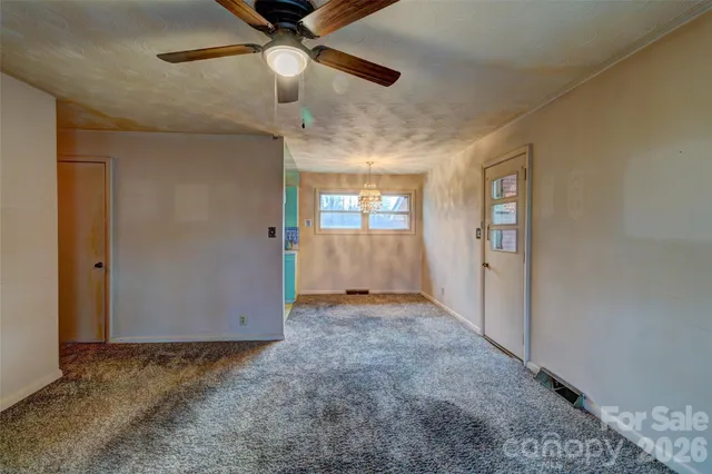 en empty room with windows and ceiling fan