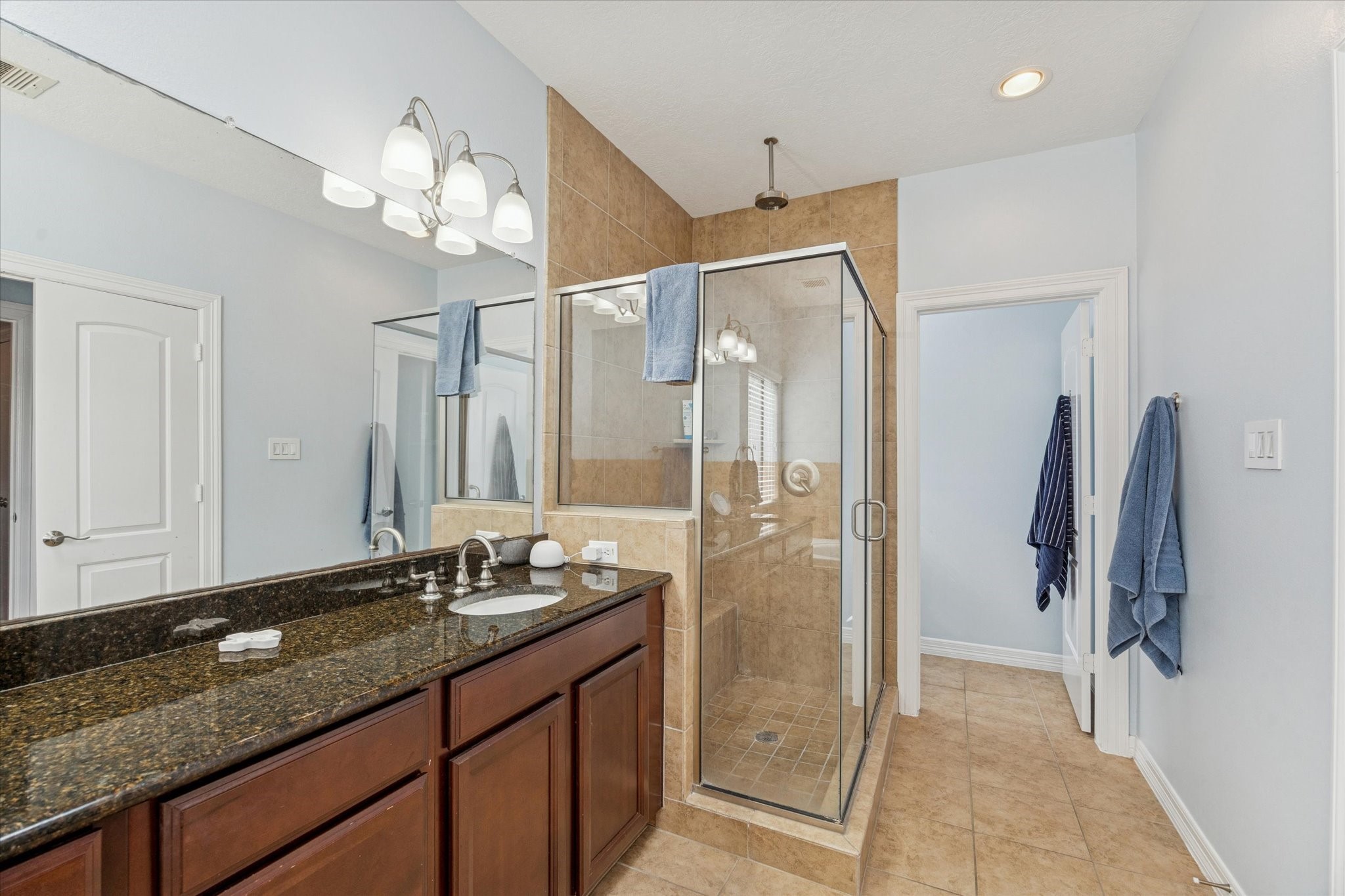 3203 Garden Oaks View Houston, TX 77018 - Photo 11 of 13 a bathroom with a granite countertop sink a large mirror and a shower
