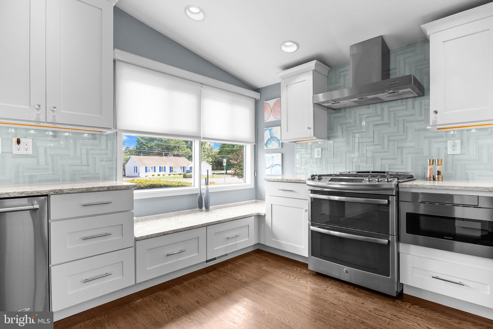 3166 Hulmeville Road Bensalem, PA 19020 - Photo 12 of 40 a kitchen with stainless steel appliances white cabinets and wooden floors