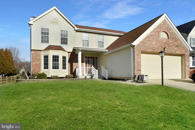 a front view of a house with a yard and trees
