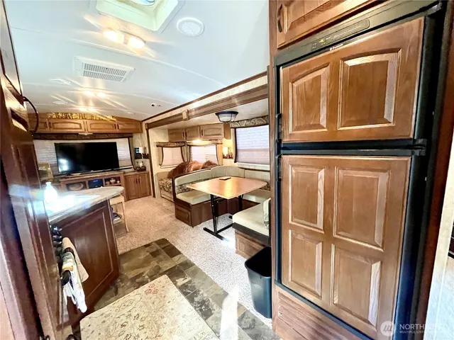 a living room with furniture a flat screen tv and floor to ceiling window