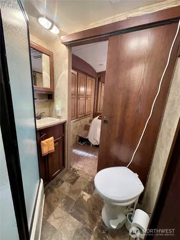 a white toilet sitting next to a bathroom sink and a mirror