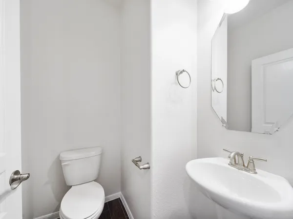 a bathroom with a toilet a sink and mirror
