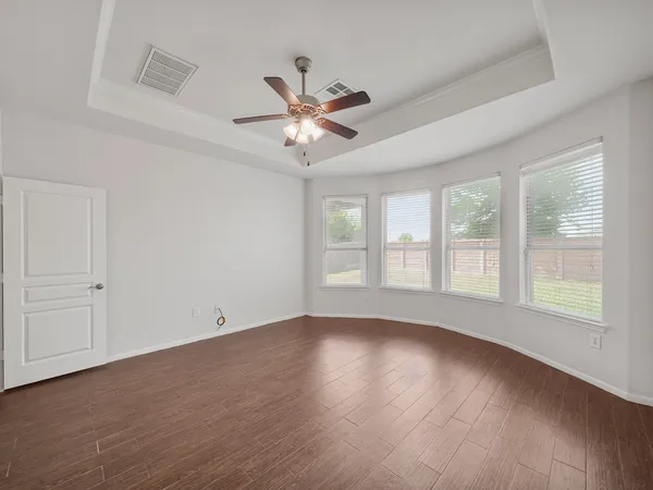 a view of wooden floor and a chandelier fan in a room