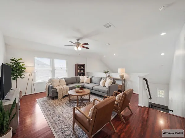 a living room with furniture and a wooden floor