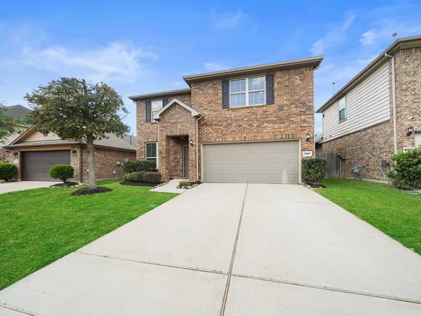 a front view of a house with a yard and a garage