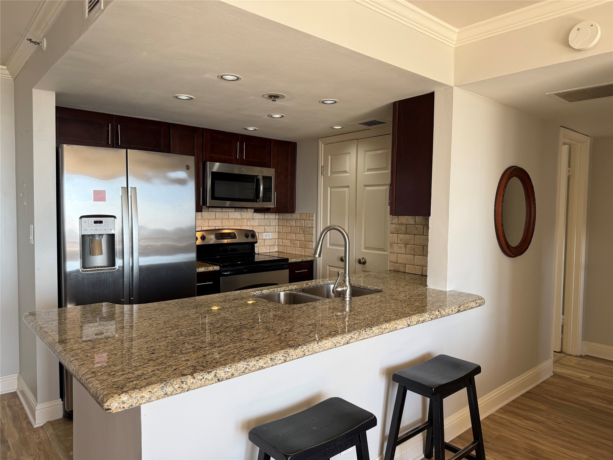 3525 Sage Road, Unit 1217 Houston, TX 77056 - Photo 3 of 27 a kitchen with granite countertop a sink a counter top space cabinets stainless steel appliances and a counter top space