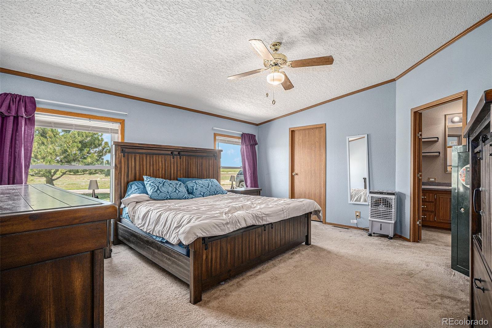 8260 County Road 39 Fort Lupton, CO 80621 - Photo 12 of 32 a bedroom with a large bed and a chandelier