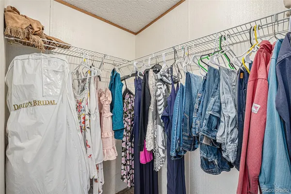 a view of walk in closet with clothes