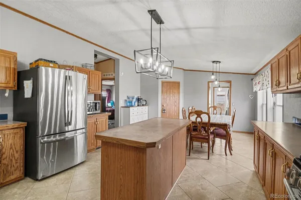 a kitchen with refrigerator and chairs