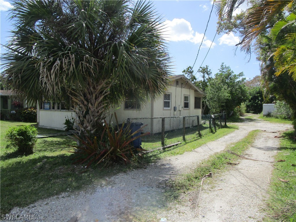 15790 Pine Ridge Road Fort Myers, FL 33908 - Photo 3 of 17 a view of house with a yard and palm trees