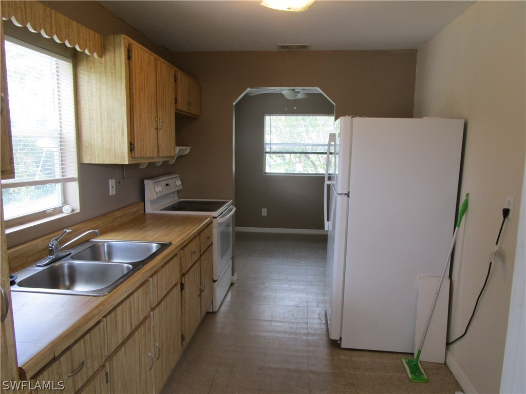 15790 Pine Ridge Road Fort Myers, FL 33908 - Photo 8 of 17 a kitchen with a sink a refrigerator and window