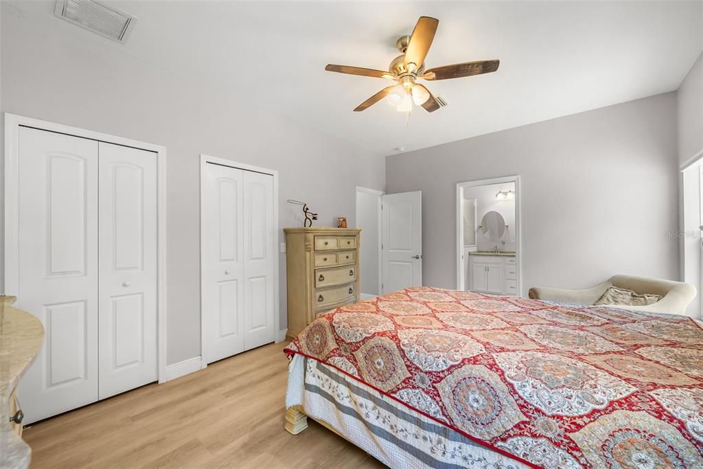 13391 Ruffed Grouse Road Weeki Wachee, FL 34614 - Photo 12 of 25 a bedroom with a bed and a chandelier