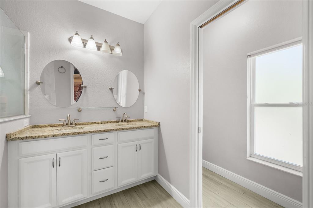 13391 Ruffed Grouse Road Weeki Wachee, FL 34614 - Photo 13 of 25 a bathroom with a granite countertop double vanity sink and a mirror