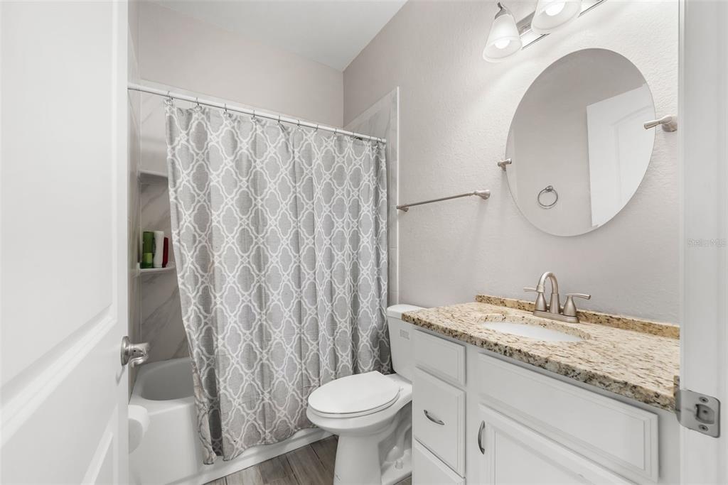 13391 Ruffed Grouse Road Weeki Wachee, FL 34614 - Photo 20 of 25 a bathroom with a granite countertop sink toilet and a mirror