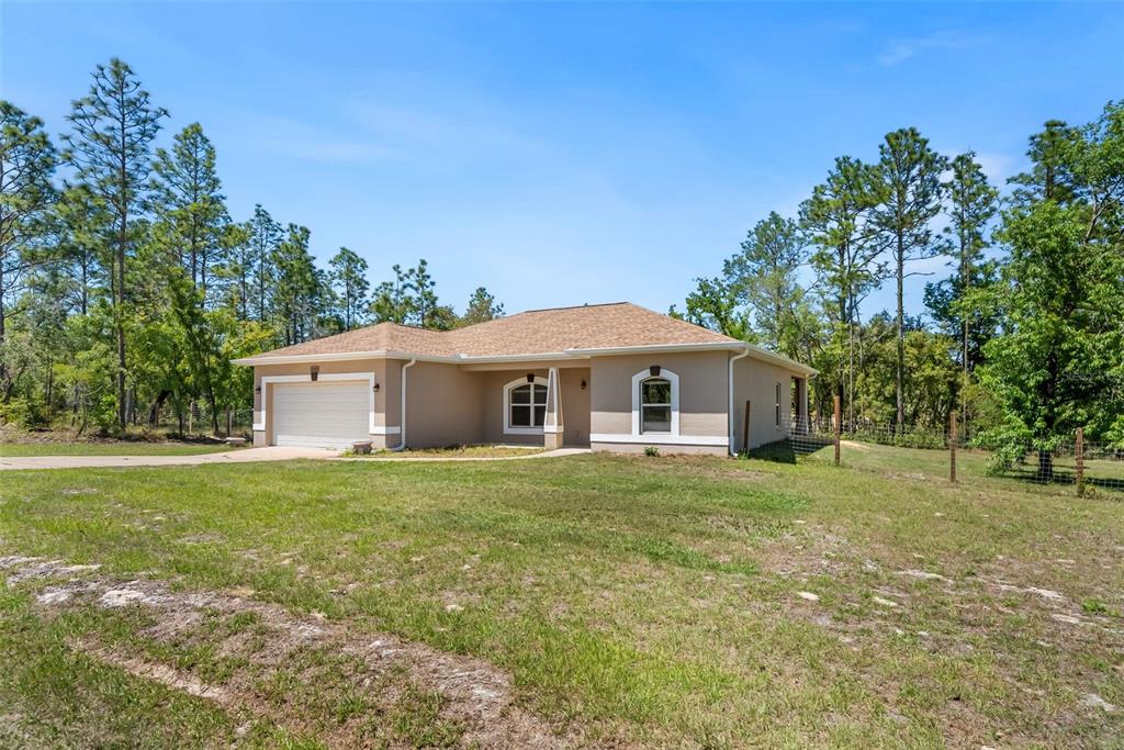 13391 Ruffed Grouse Road Weeki Wachee, FL 34614 - Photo 3 of 25 a large house with a big yard and large trees
