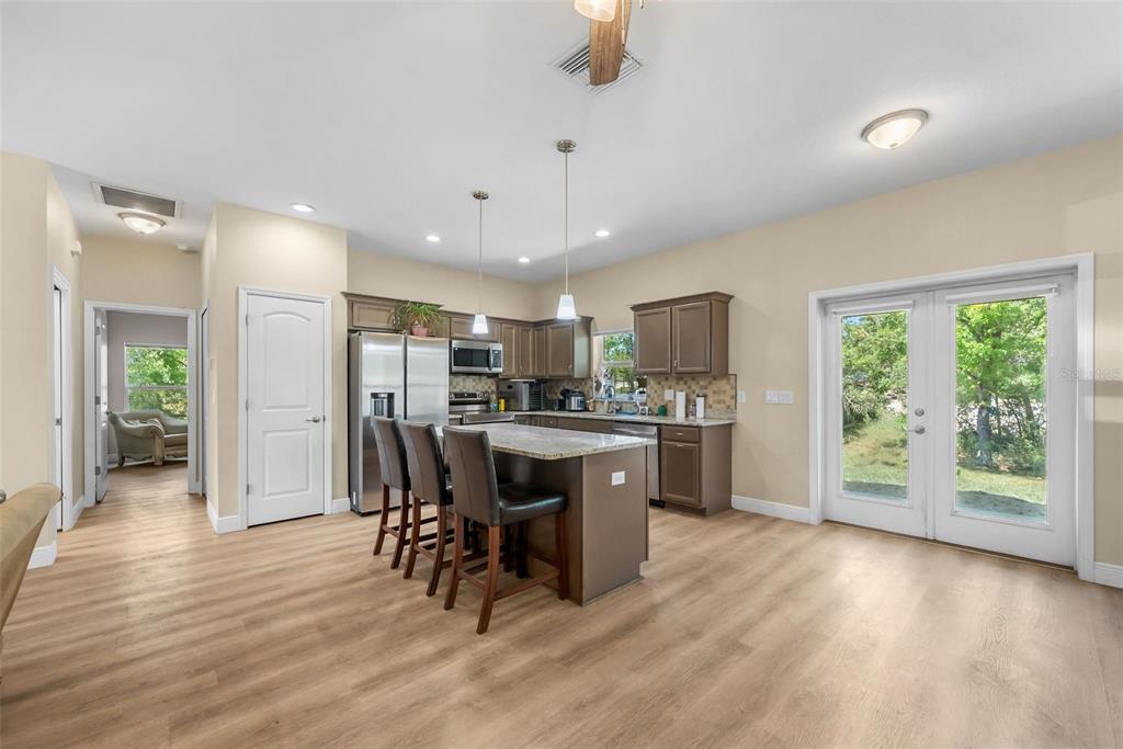 13391 Ruffed Grouse Road Weeki Wachee, FL 34614 - Photo 5 of 25 a kitchen with kitchen island granite countertop a refrigerator cabinets and wooden floor
