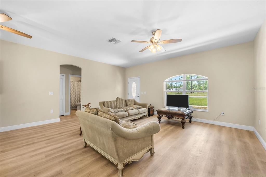 13391 Ruffed Grouse Road Weeki Wachee, FL 34614 - Photo 9 of 25 a living room with furniture a chandelier and a window
