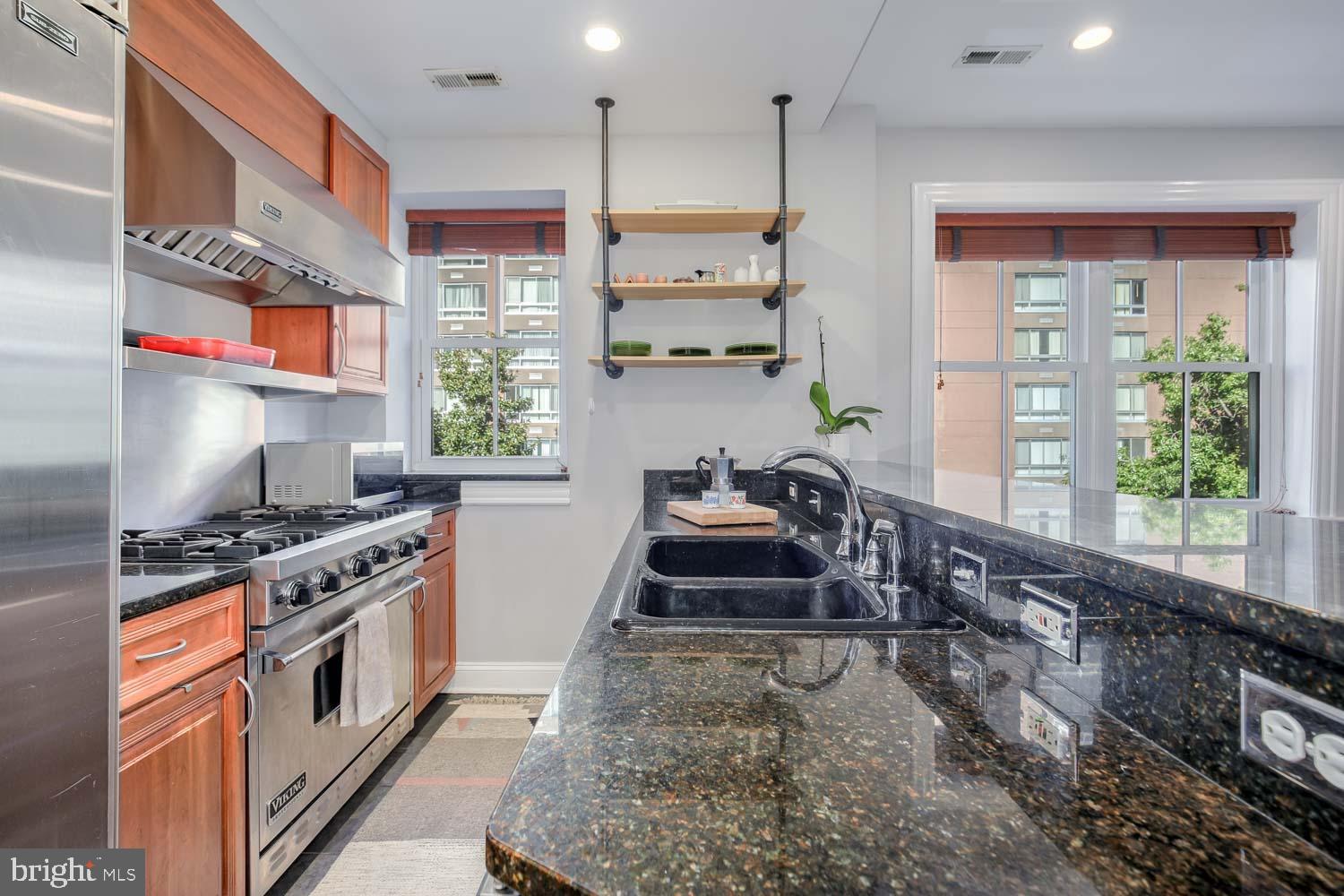 1212 M Street Northwest, Unit 401 Washington, DC 20005 - Photo 6 of 16 a kitchen with stainless steel appliances granite countertop a stove a sink and a refrigerator