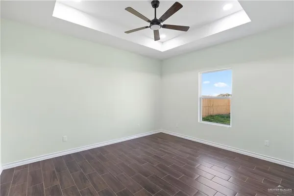 an empty room with a window and a ceiling fan