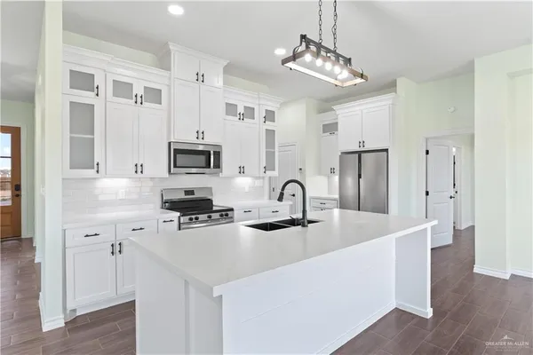 a kitchen with stainless steel appliances a sink stove and refrigerator