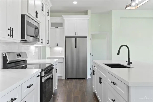 a kitchen with stainless steel appliances granite countertop a sink stove and refrigerator
