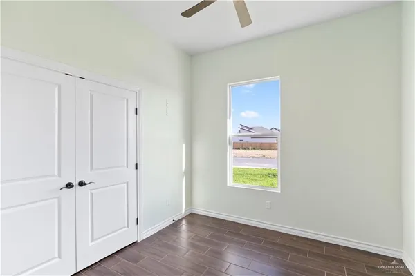 a view of an empty room with closet and a window
