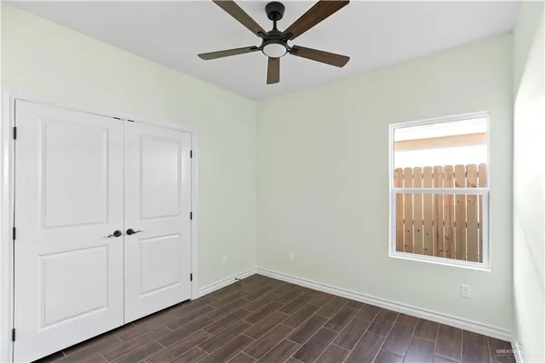 a view of room with hardwood floor and a ceiling fan