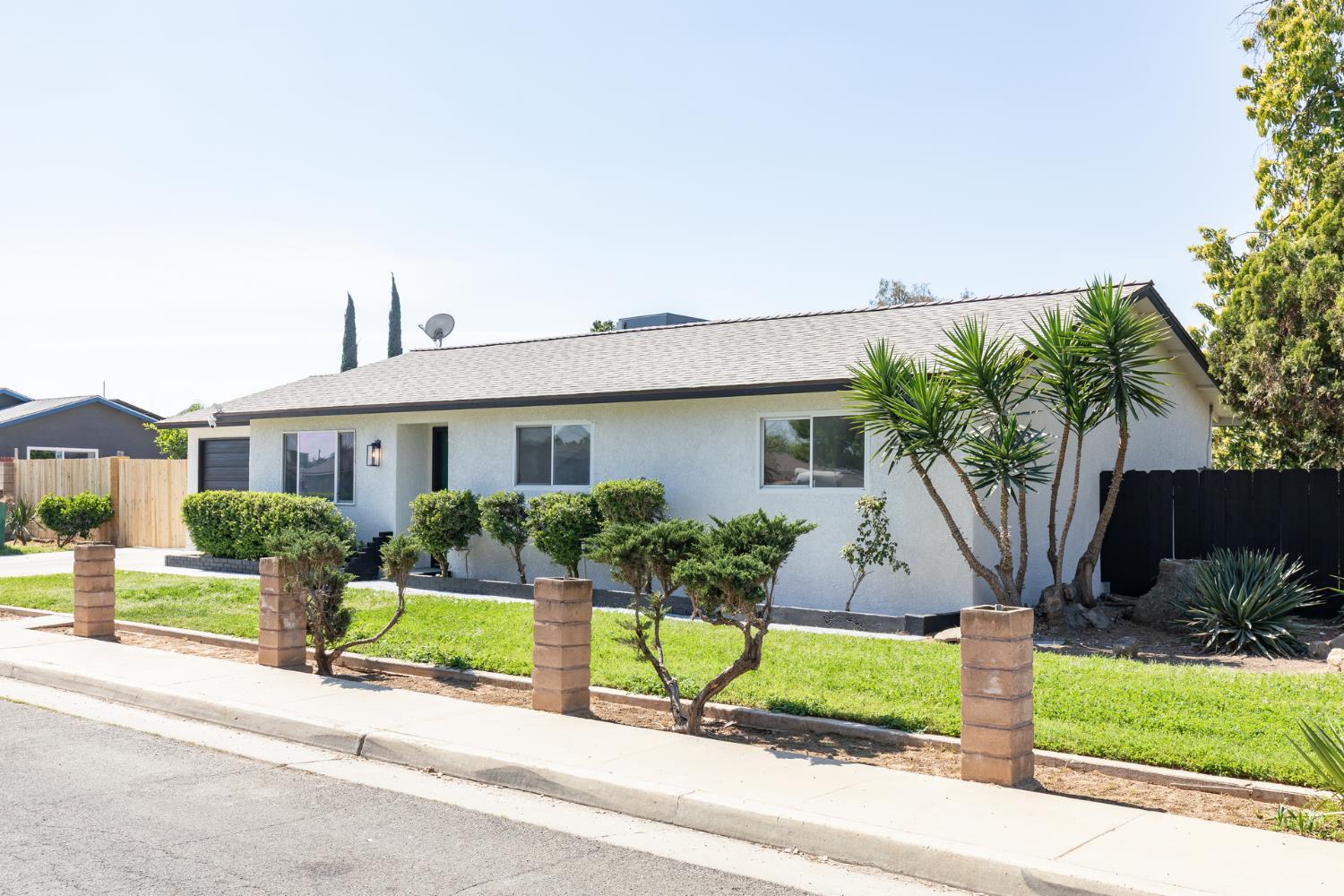 1185 East Evening Glow Circle Reedley, CA 93654 - Photo 2 of 42 a front view of a house with garden and plants