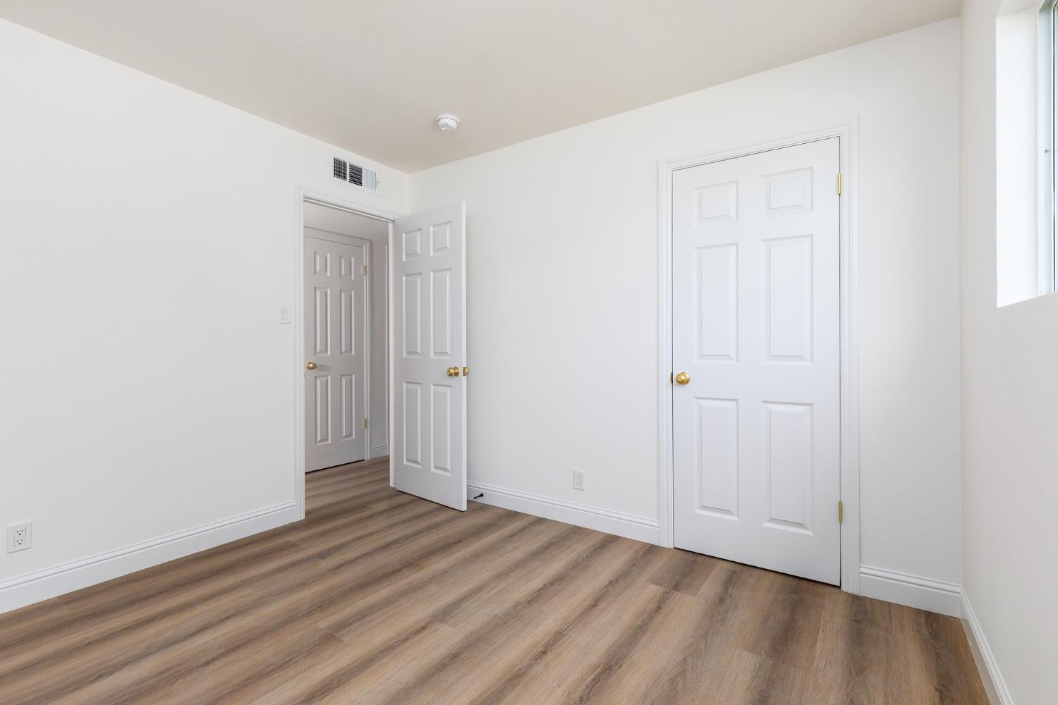 1185 East Evening Glow Circle Reedley, CA 93654 - Photo 23 of 42 a view of an empty room with wooden floor