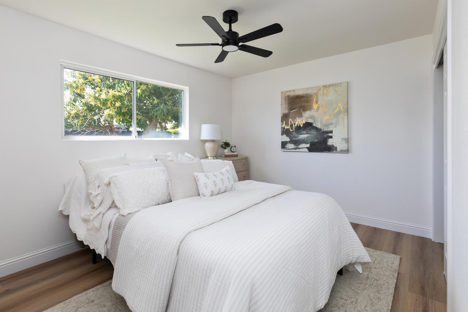 1185 East Evening Glow Circle Reedley, CA 93654 - Photo 28 of 42 a bedroom with a bed and a painting on the wall