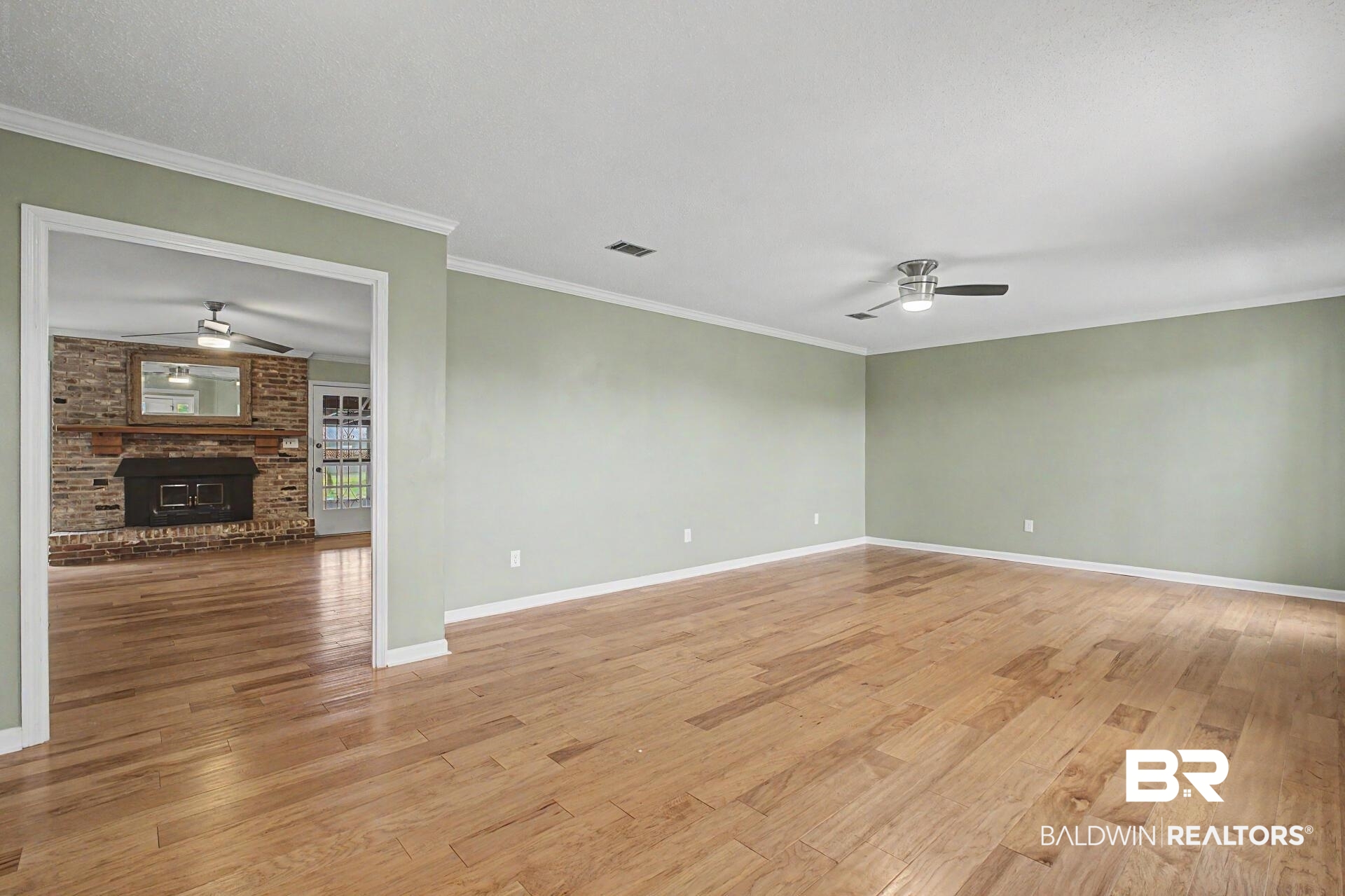 3791 Robinsonville Road Atmore, AL 36502 - Photo 34 of 47 Spacious interior room featuring wood-finish flooring, light green wall paint, and white crown molding