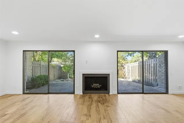 an empty room with floor to ceiling window and an outdoor view