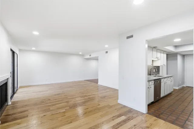 a view of kitchen with granite countertop cabinets and refrigerator
