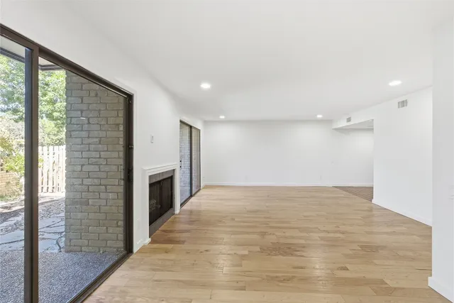 a view of an empty room with a fireplace and a window