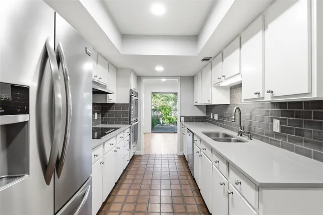 a kitchen with stainless steel appliances a sink stove and refrigerator