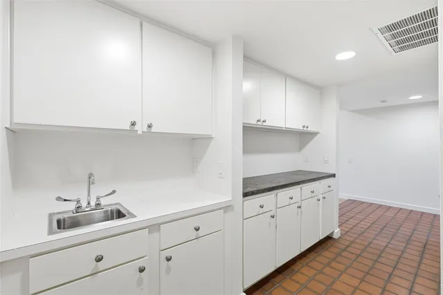a kitchen with granite countertop white cabinets and sink