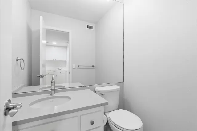 a bathroom with a sink toilet and mirror