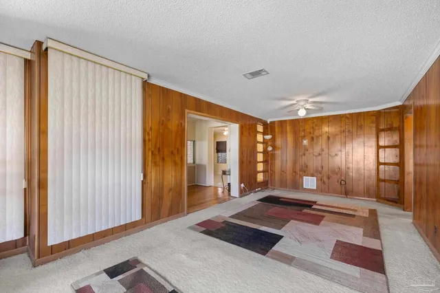 an empty room with a window and a ceiling fan