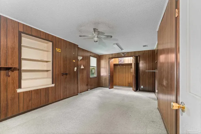 an empty room with ceiling fan and window