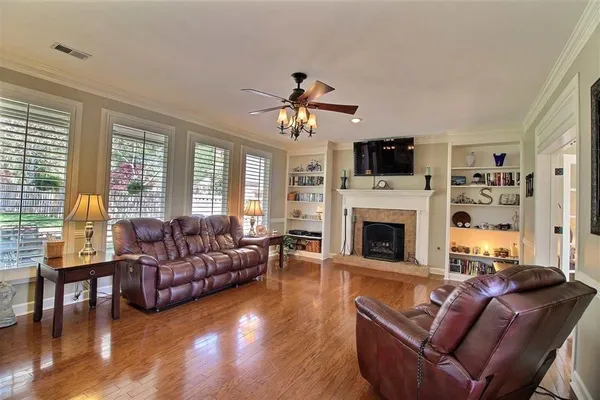 a living room with furniture a fireplace and a flat screen tv