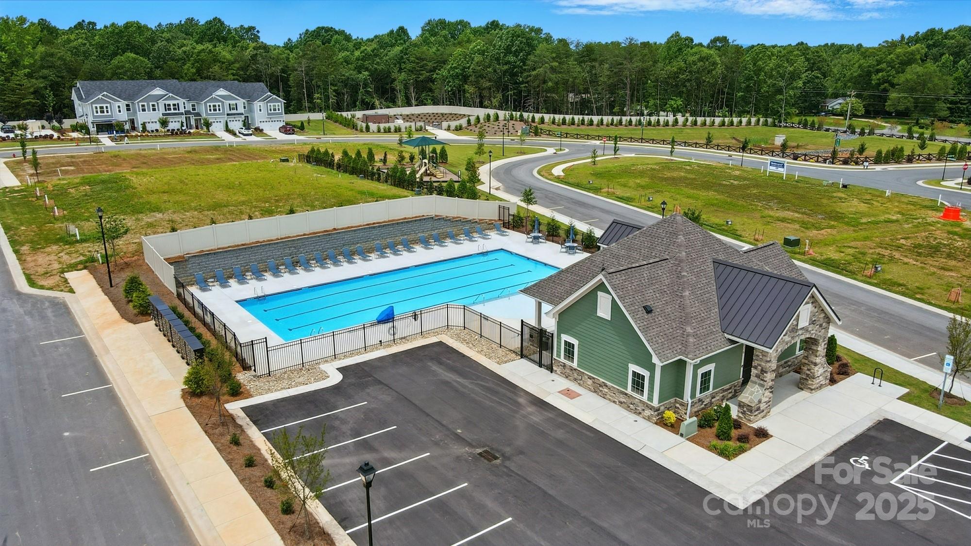 645 Cassidy Court Clover, SC 29710 - Photo 29 of 31 a view of a swimming pool with lawn chairs plants and large trees