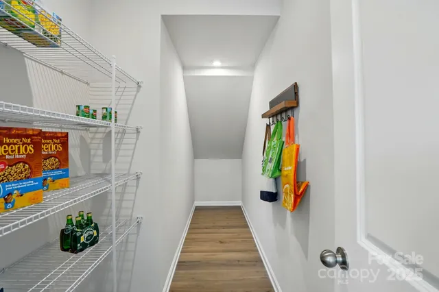 a view of a hallway with wooden floor and furniture
