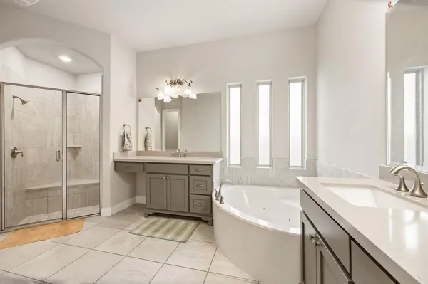 a bathroom with a tub sink and mirror