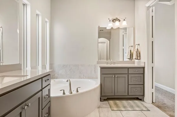 a bathroom with a bathtub sink and mirror